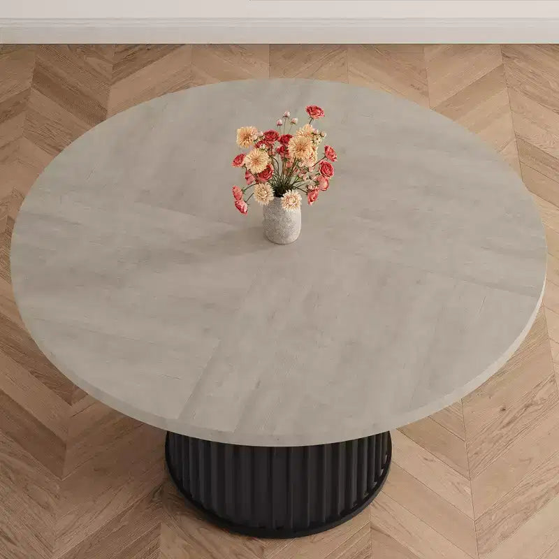 Table à manger ronde avec un piètement en métal ondulé